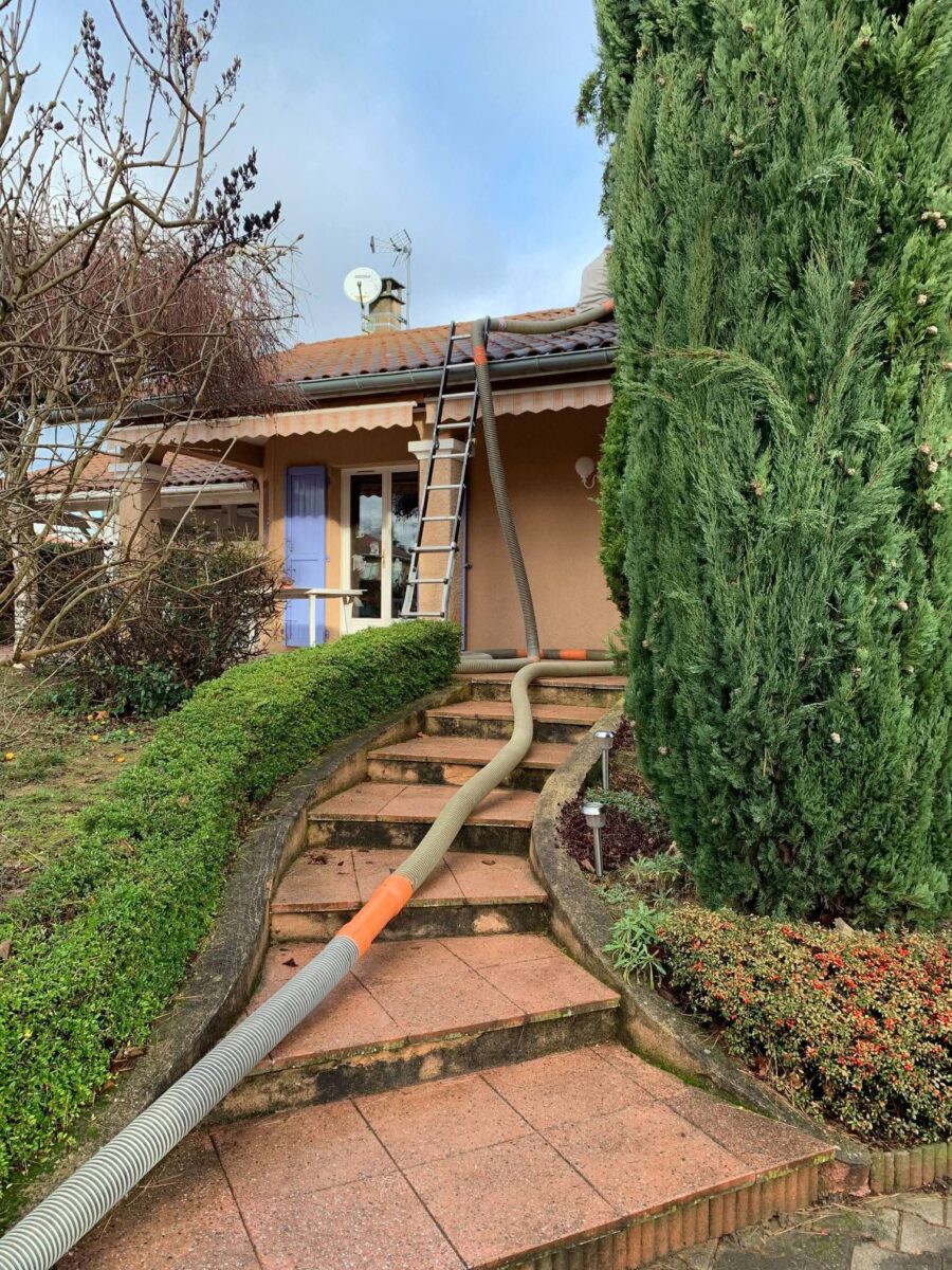 Mise en place du tuyau de soufflage pour isolation des combles d'une maison à Mionnay