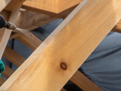 Gros plan sur une poutre de charpente en bois clair traitée par pulvérisation préventive