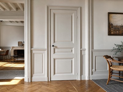 Porte intérieure classique à panneaux et moulures dans un intérieur traditionnel