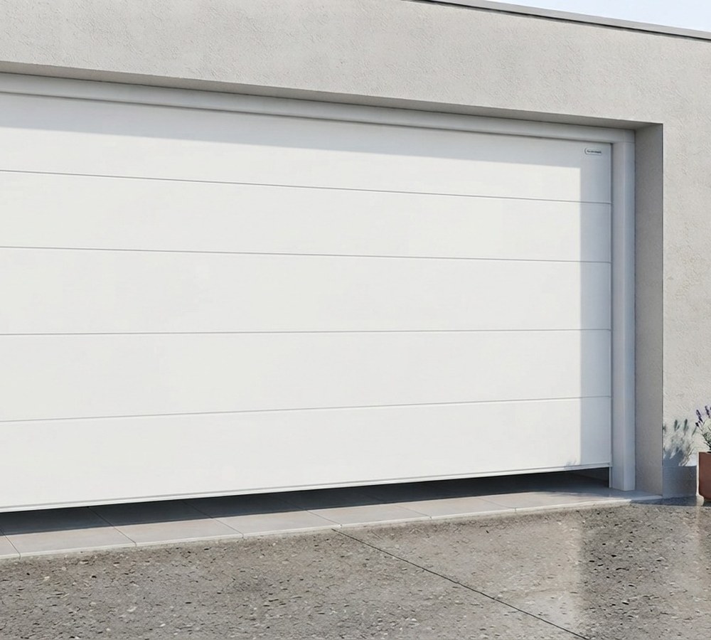 Artisan Maison Française de l'Artisanat installant une porte de garage sectionnelle grise sur une maison individuelle