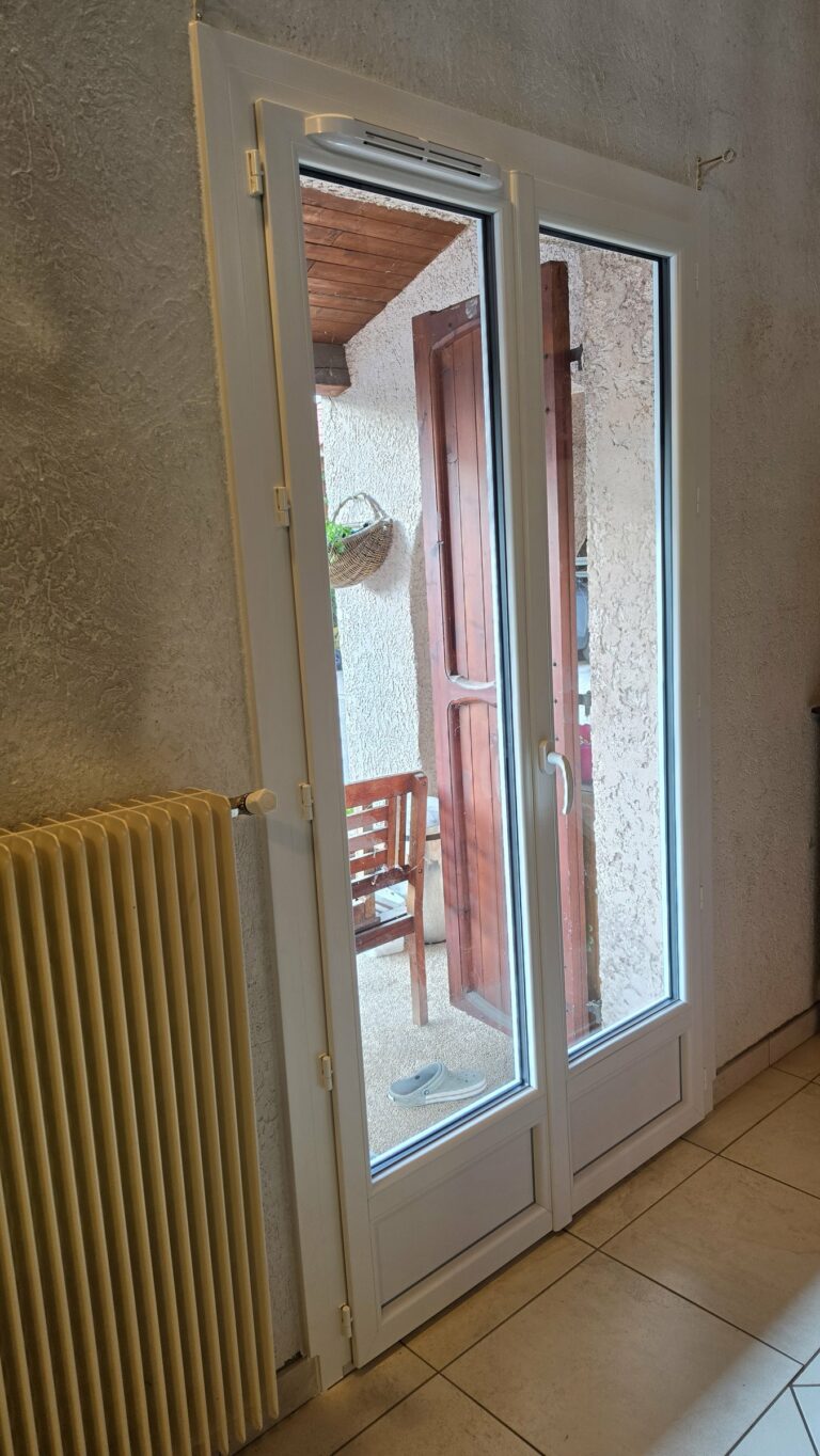 Porte-fenêtre PVC blanc avec soubassement et aérateur, vue intérieure à Miribel