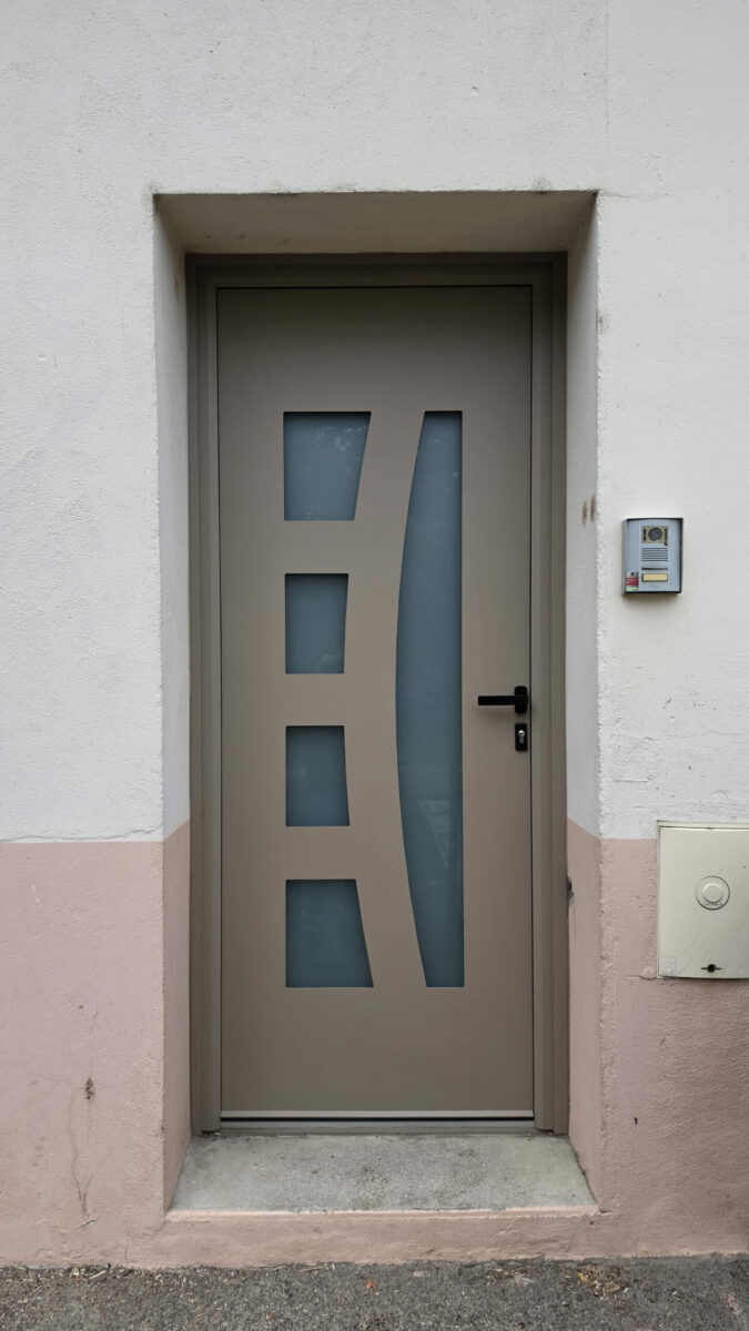 Porte d'entrée aluminium taupe avec vitrages dépolis et poignée noire, posée à Condeissiat